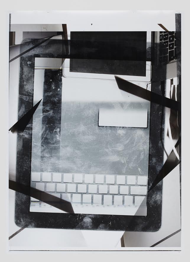 Tablet and keyboard partially obscured by black tape and paper layers